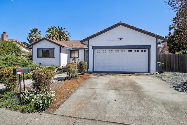 single story home featuring driveway, fence, an attached garage, and a tile roof