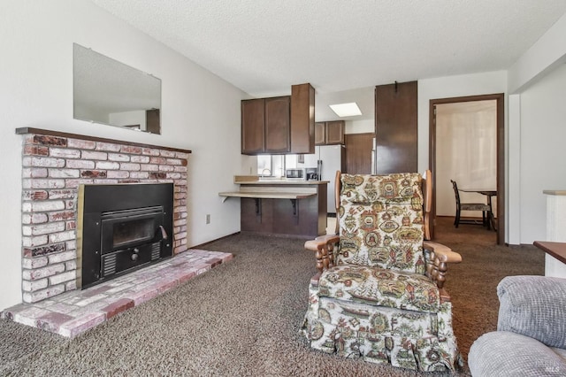 living area featuring a fireplace, carpet floors, and a textured ceiling