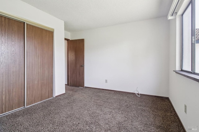 unfurnished bedroom with a closet, a textured ceiling, and carpet