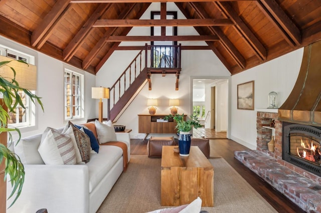 living room with wood finished floors, baseboards, beam ceiling, stairs, and wood ceiling