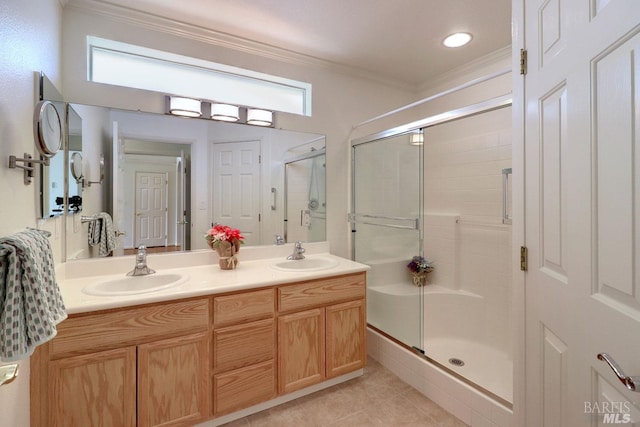 bathroom featuring a sink, a shower stall, and crown molding