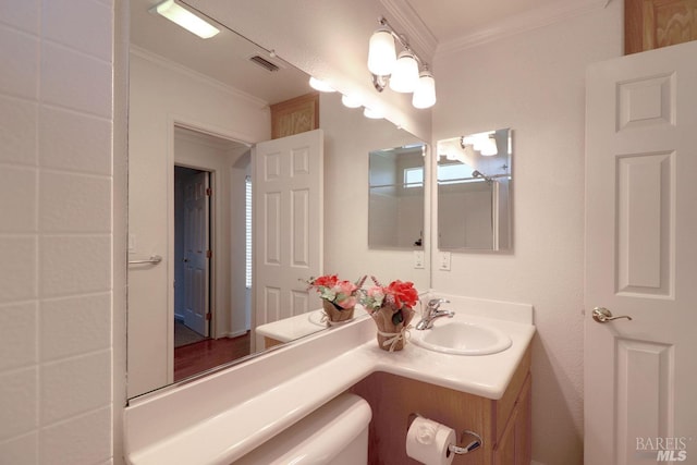 bathroom featuring toilet, visible vents, crown molding, and vanity