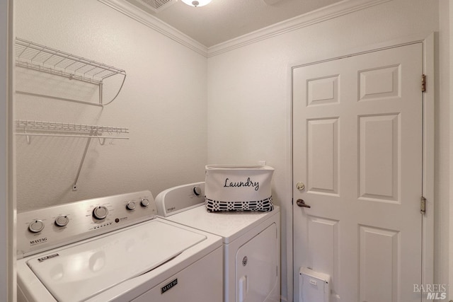 laundry area featuring ornamental molding, washing machine and dryer, and laundry area