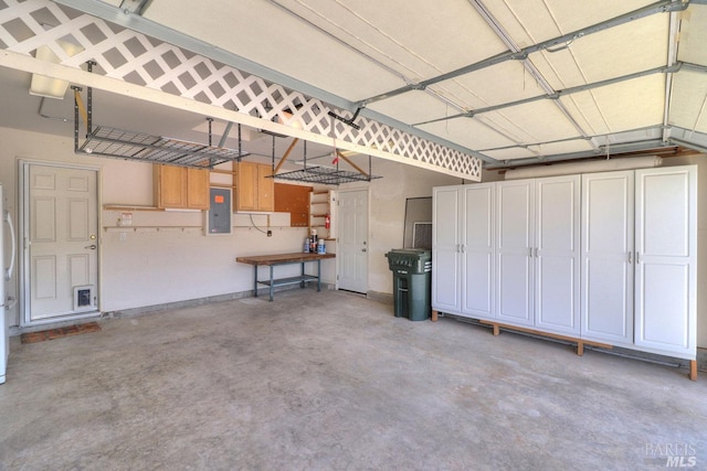 garage with freestanding refrigerator and electric panel