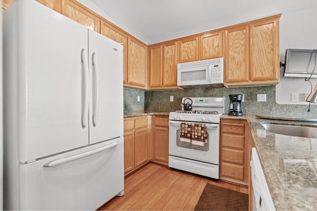 kitchen with white appliances, tasteful backsplash, light stone counters, and light wood-style floors