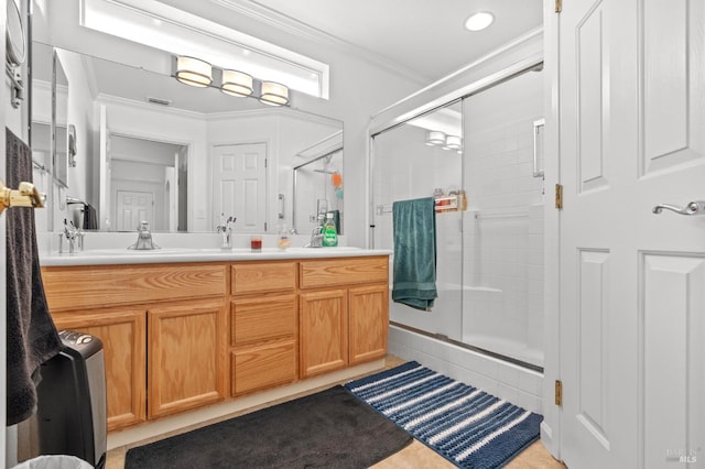 bathroom featuring a sink, visible vents, ornamental molding, a shower stall, and double vanity