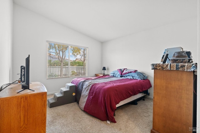 carpeted bedroom with vaulted ceiling and baseboards