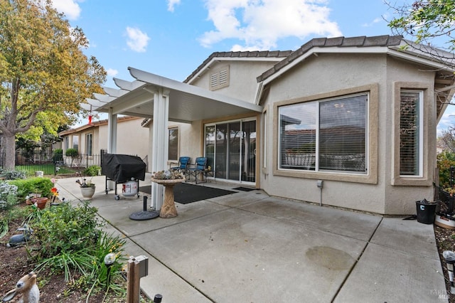 back of property with a patio area, fence, and stucco siding