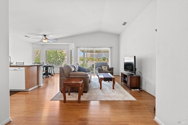 living area featuring lofted ceiling, a ceiling fan, baseboards, visible vents, and light wood-style floors