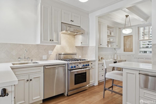 2401 Jackson St Unit 3, San Francisco, CA 94115 - kitchen featuring under cabinet range hood, stainless steel appliances, a sink, a warming drawer, and light countertops