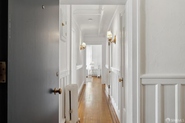 hall with light wood-style floors and radiator heating unit