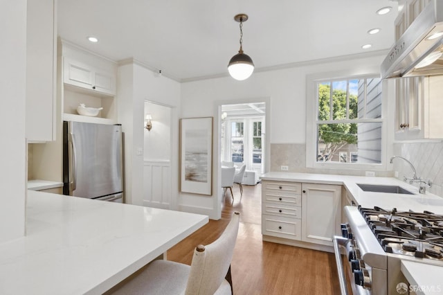 2401 Jackson St Unit 3, San Francisco, CA 94115 - kitchen featuring stainless steel appliances, under cabinet range hood, a sink, hanging light fixtures, and light wood-style flooring
