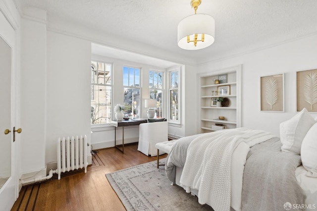 2401 Jackson St Unit 3, San Francisco, CA 94115 - bedroom with radiator, wood finished floors, a desk, a textured ceiling, and baseboards