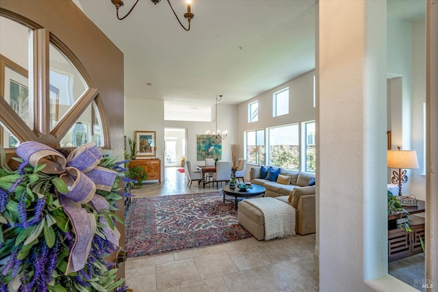 tiled living room with a high ceiling and an inviting chandelier