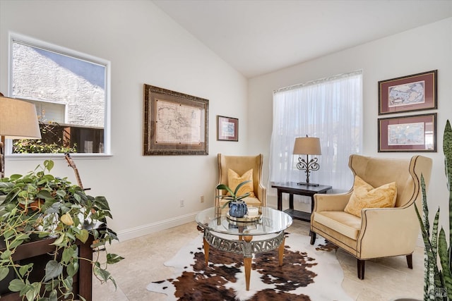 living area with lofted ceiling and baseboards