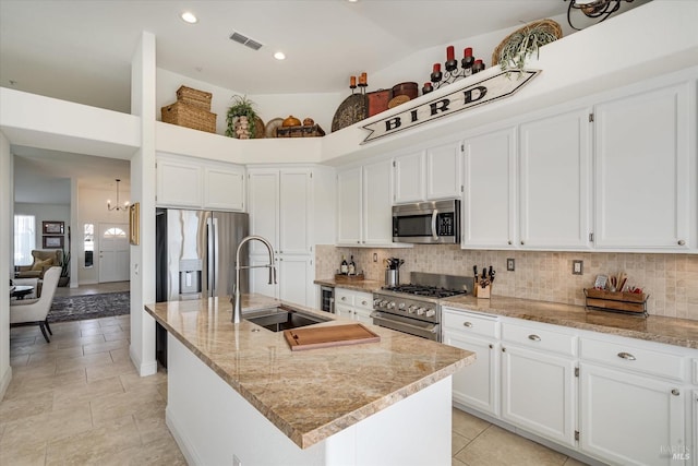 kitchen featuring visible vents, stainless steel appliances, decorative backsplash, and a sink