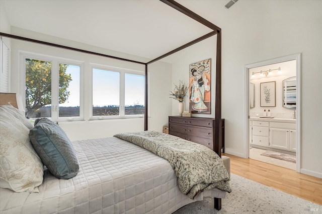 bedroom with visible vents, connected bathroom, light wood-type flooring, and baseboards