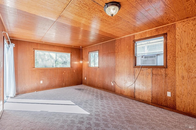 carpeted empty room with cooling unit, wooden ceiling, and wood walls