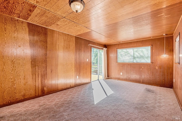 spare room featuring carpet, wood ceiling, and wooden walls