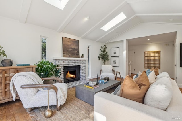 living area with a skylight, wood finished floors, beamed ceiling, a brick fireplace, and recessed lighting