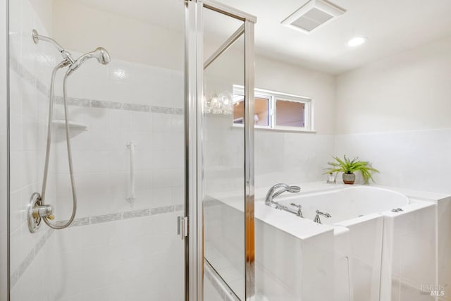 bathroom featuring a bath, a shower stall, and visible vents