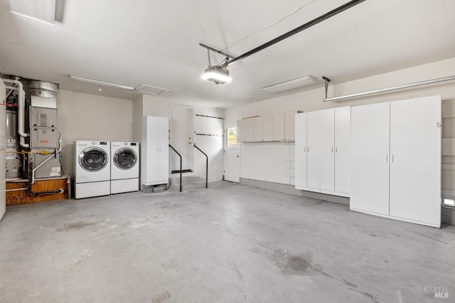 garage with heating unit, washer and dryer, and a garage door opener