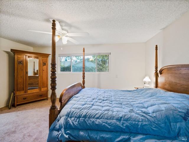 bedroom with a ceiling fan, light colored carpet, and a textured ceiling