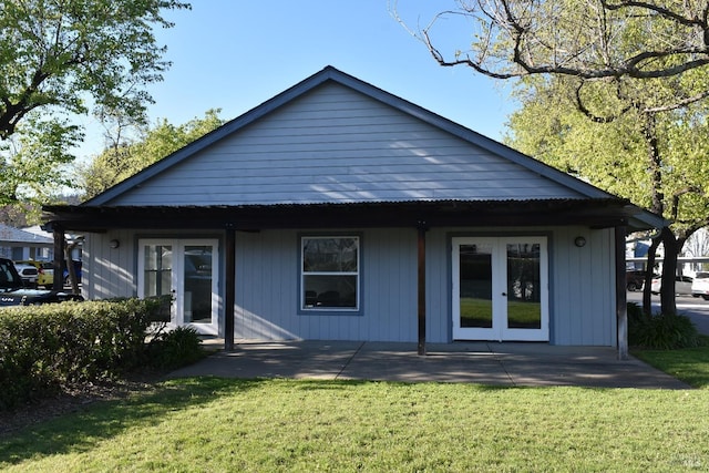 back of property featuring a yard, french doors, and a patio area