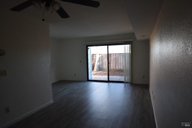 unfurnished room with ceiling fan, a textured wall, baseboards, and wood finished floors