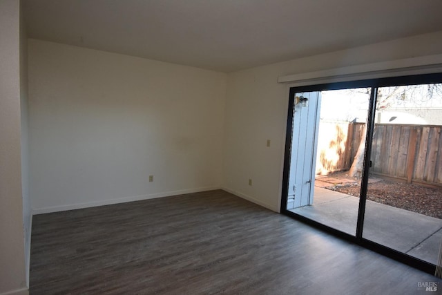 empty room featuring dark wood-type flooring and baseboards