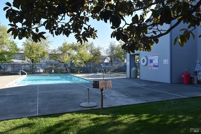 pool with a patio area and fence