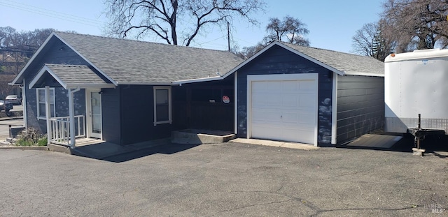 view of front of property with a shingled roof and a garage