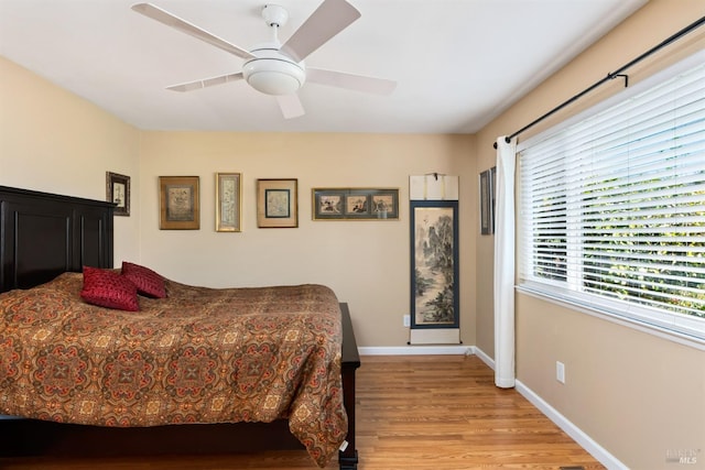 bedroom featuring baseboards, a ceiling fan, and light wood finished floors