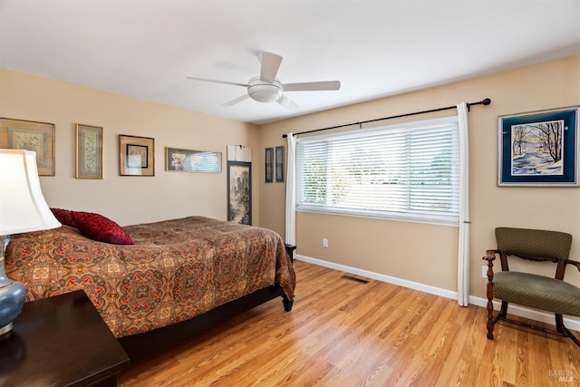 bedroom featuring visible vents, light wood-style flooring, a ceiling fan, and baseboards