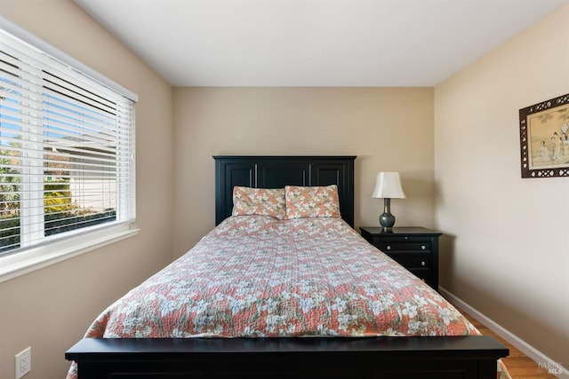 bedroom featuring wood finished floors and baseboards