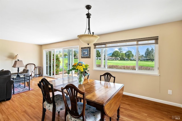 dining area with light wood-style flooring and baseboards