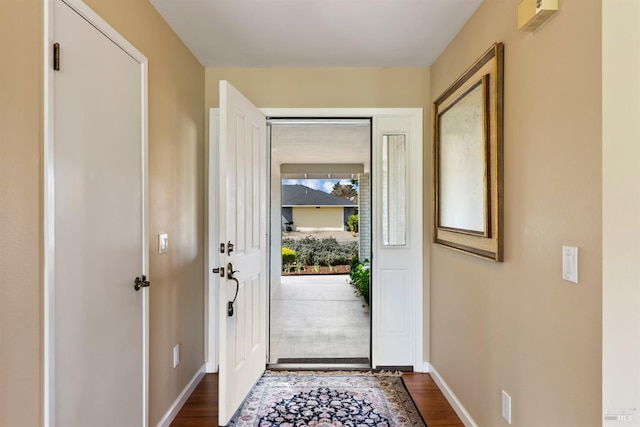 entryway with dark wood-type flooring and baseboards