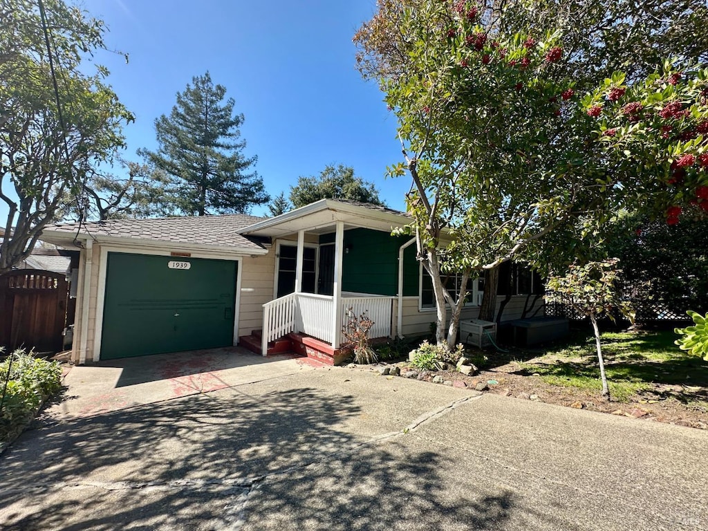 view of front of property with concrete driveway, a porch, and an attached garage