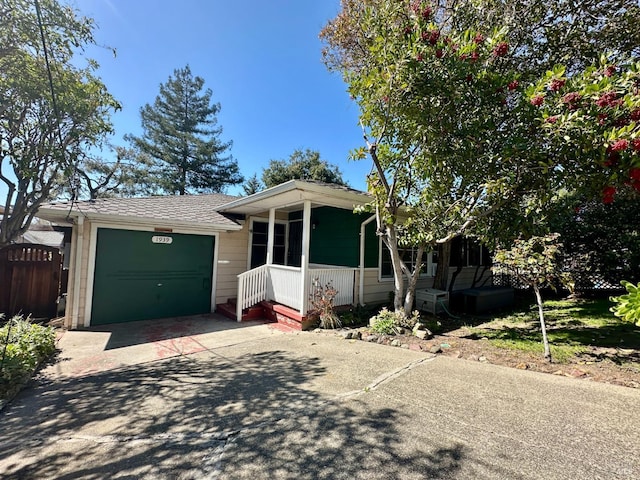 view of front of property with concrete driveway, a porch, and an attached garage