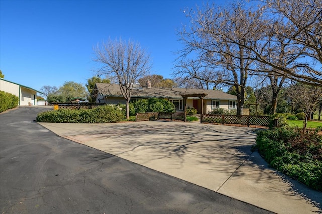 ranch-style home with a fenced front yard and driveway