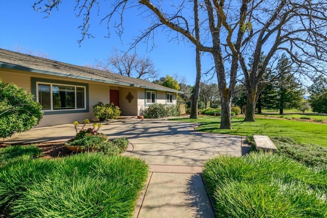 exterior space featuring a yard and stucco siding