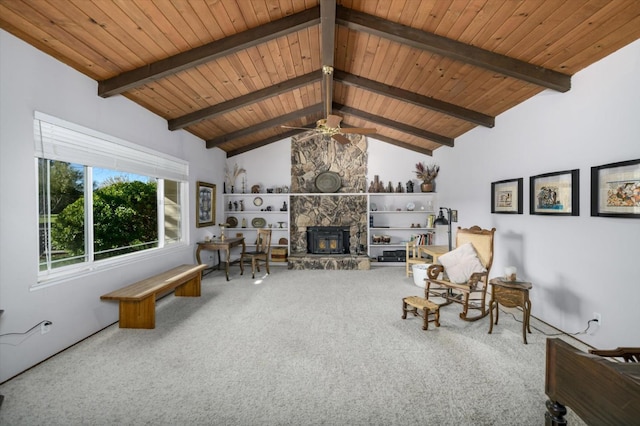 unfurnished living room featuring beamed ceiling, carpet floors, a stone fireplace, and wooden ceiling