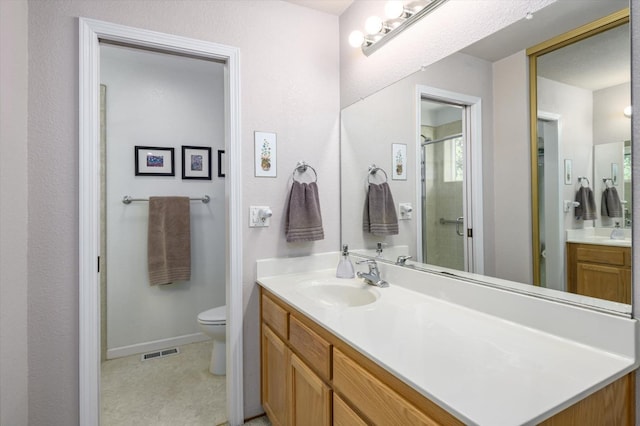 bathroom featuring visible vents, baseboards, toilet, a stall shower, and vanity