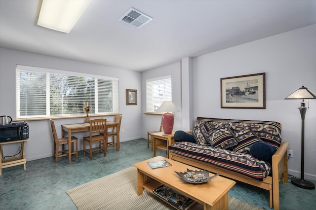 living area with visible vents, baseboards, and carpet floors