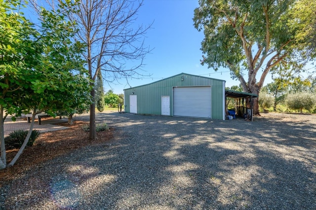 garage with driveway and a detached garage