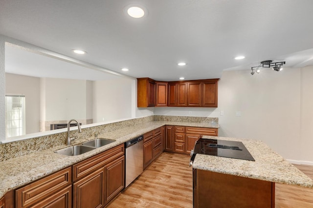 kitchen with light wood-style floors, stainless steel dishwasher, a sink, and recessed lighting