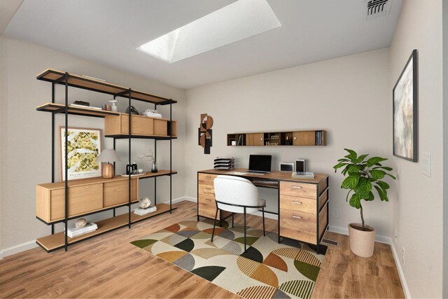 office space with a skylight, wood finished floors, baseboards, and visible vents