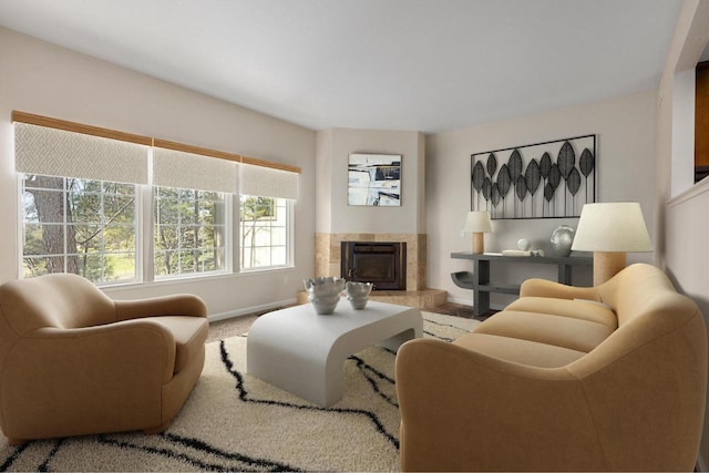 living area with carpet floors, baseboards, and a tile fireplace