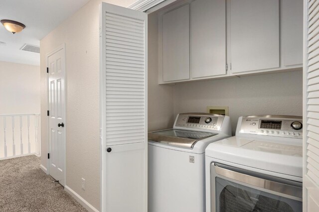 laundry room featuring carpet, separate washer and dryer, visible vents, and cabinet space