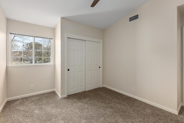 unfurnished bedroom with visible vents, baseboards, a closet, and carpet floors